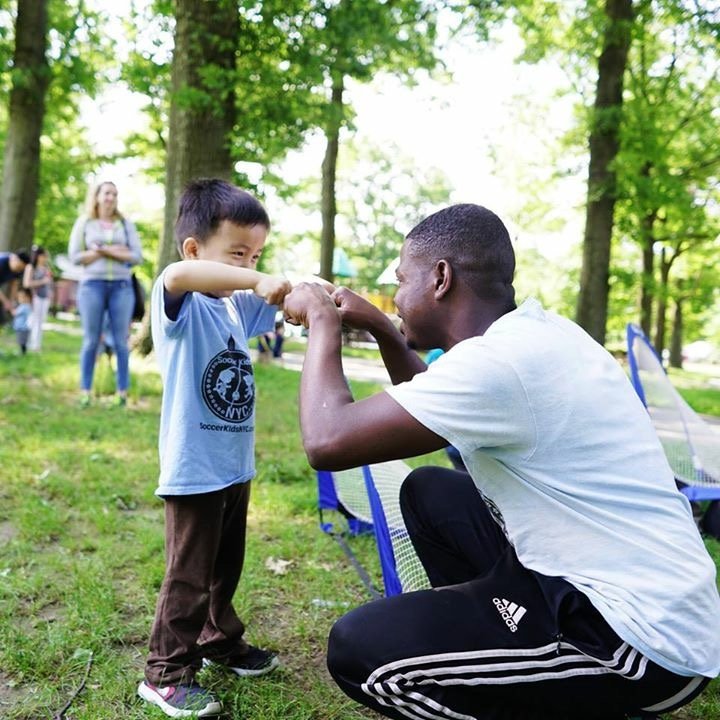 The soccer player is giving their coach a fist bump